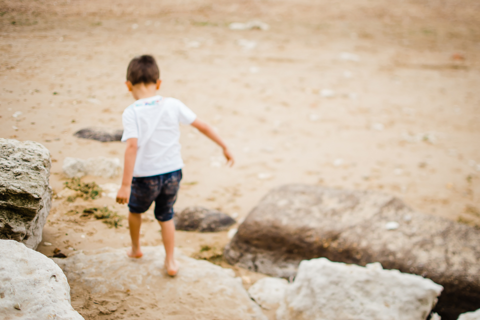 Young boy walking off the rocks at Hunstanton cliffs