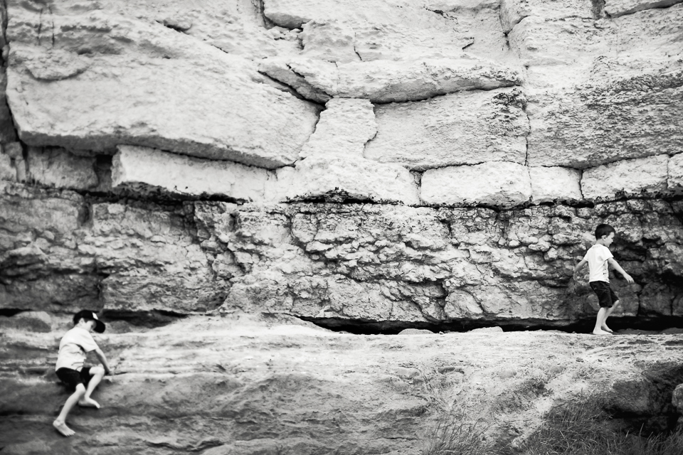 Black and white photograph of children climbing cliffs at Old Hu