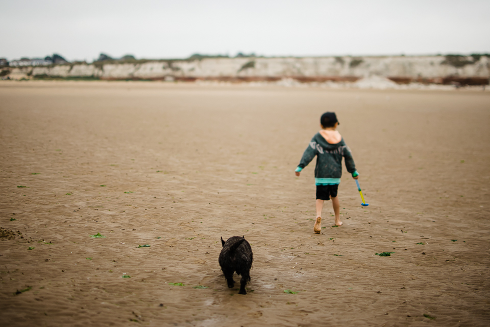 Boy and his dog walking on the beach at Hunstanton beach