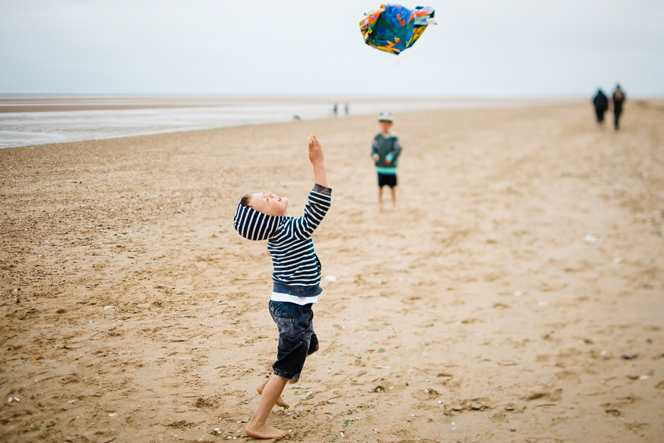 Young boy attempts to fly his kite at Hunstanton beach