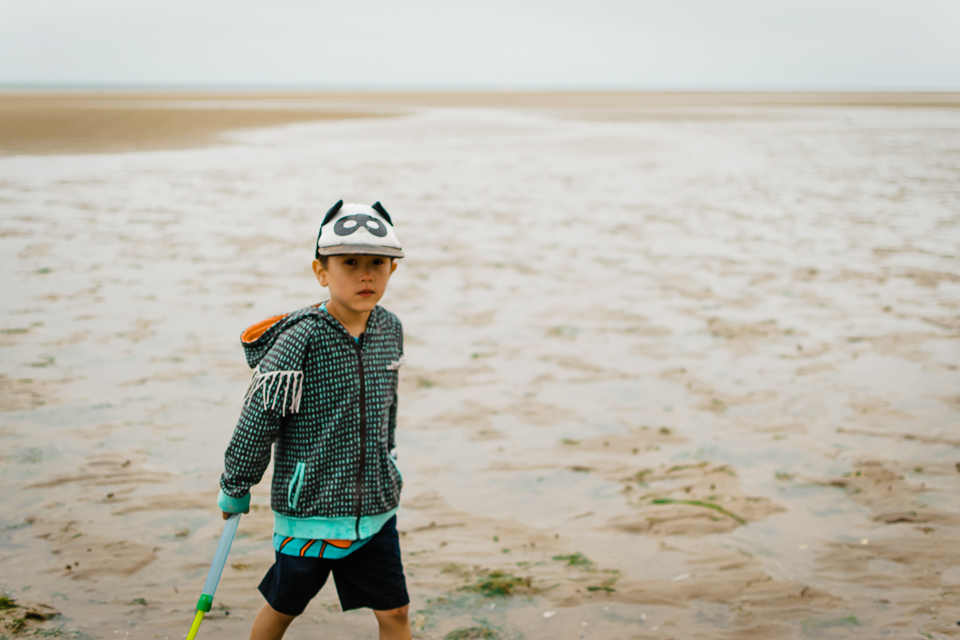 Boy with a bat mask cap on the beach in Hunstanton