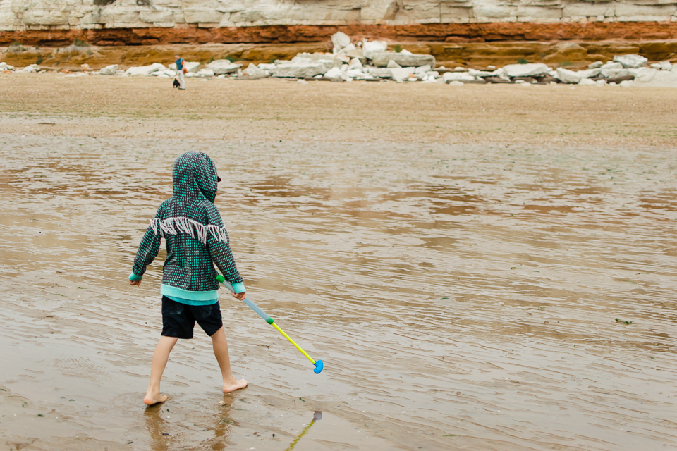 Boy with his water pistol on the beach in North Norfolk