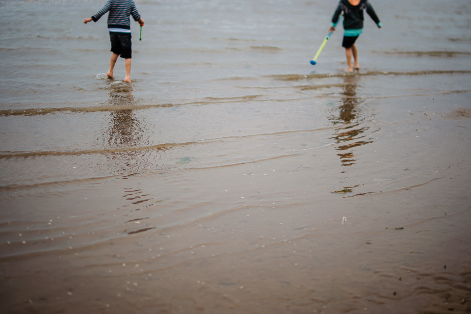 Children and shadows in the sea on Hunstanton beach