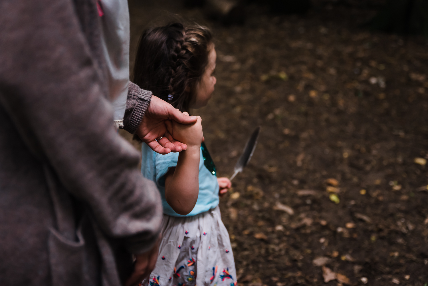 A duaghter holding onto her mother's hand