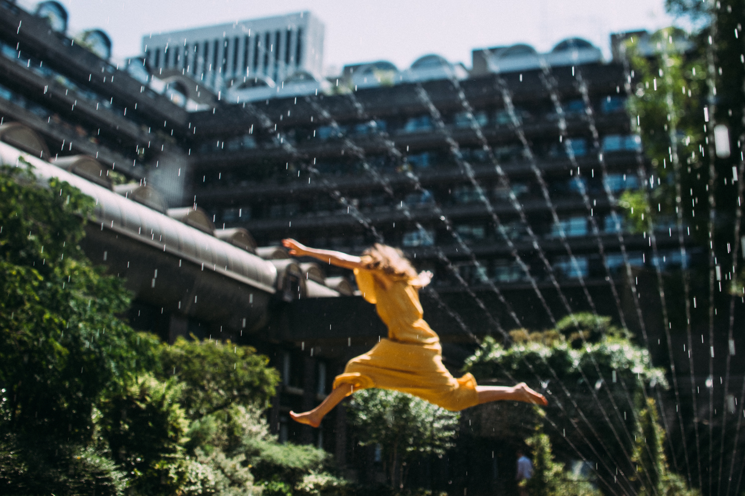 Model Sam Payne jumps through sprinklers at the Barbican