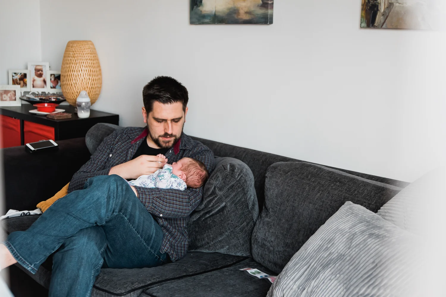 Father cradling his baby in his arms on the sofa