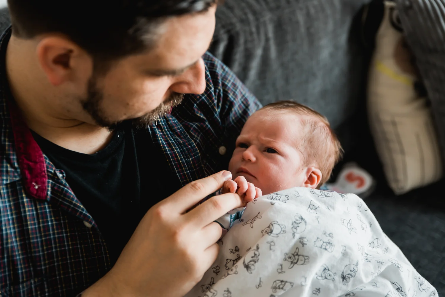 Baby holding her father's finger and making eye contact