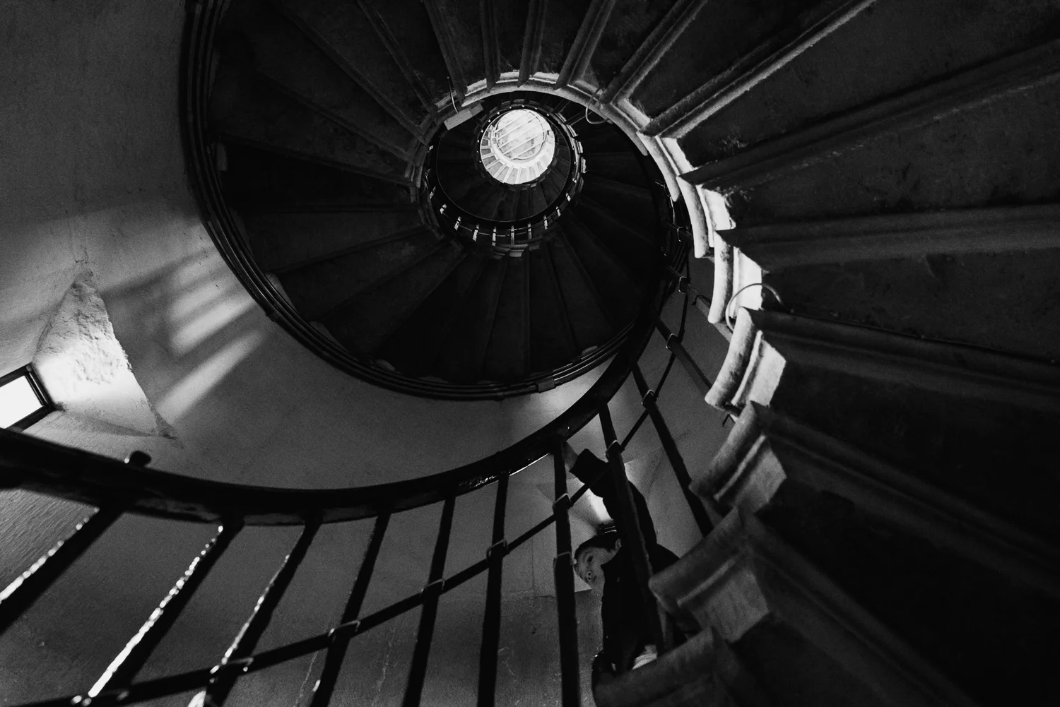Black and white photographer of a boy walking down the spiral st