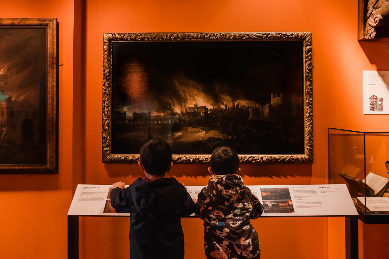 Two children looking at the painting of the Great Fire of London