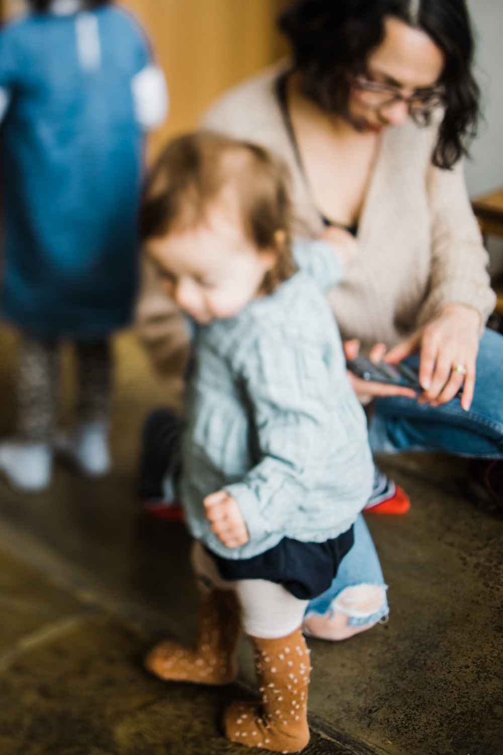 Copy of A toddler reaches for her mum's jumper