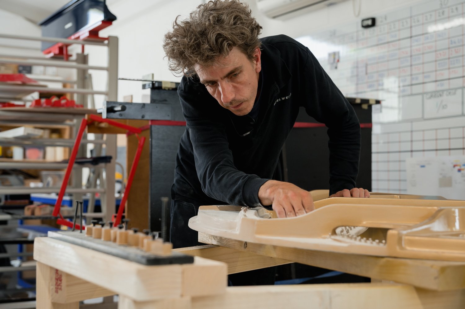  An artisan from Edelweiss Pianos working in the piano workshop in Cambridge, UK. 