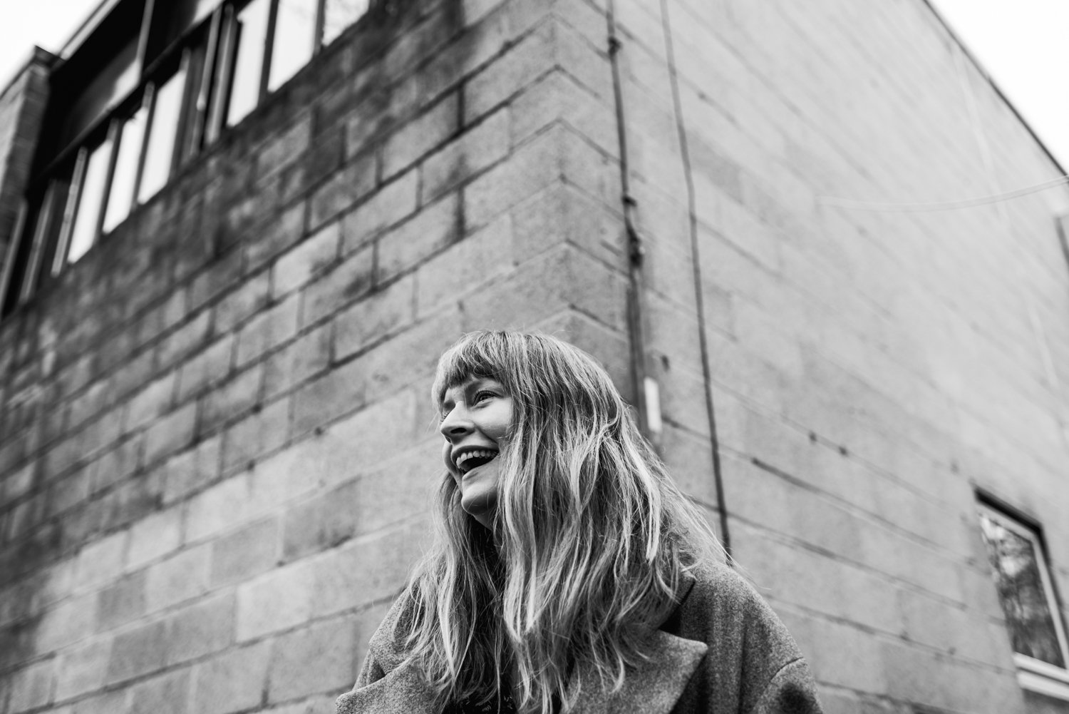  Portrait of female photographer, Ami Robertson, outside a brick building in Stoke Newington, London.  