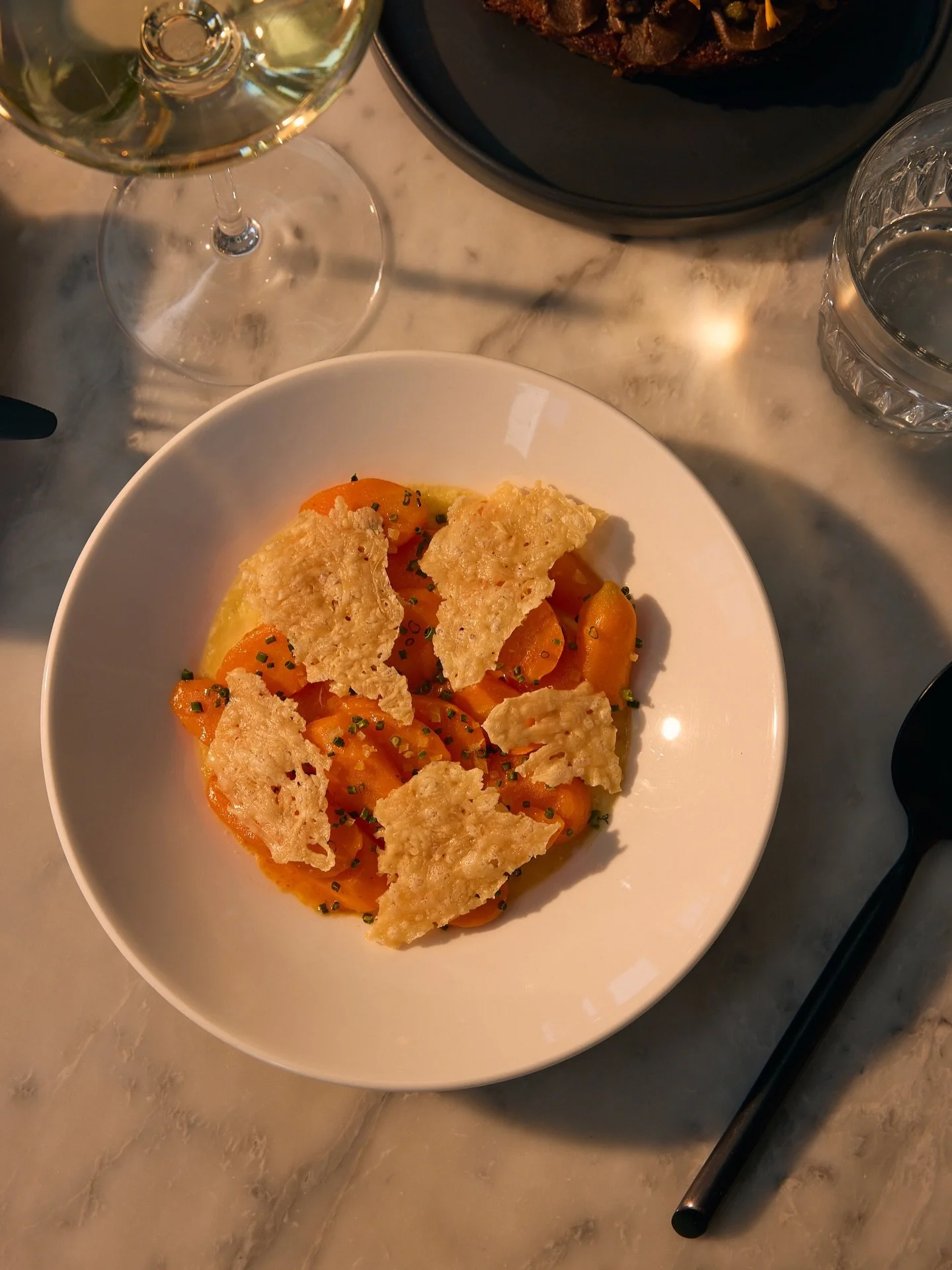 carrots are the star here &ndash; glazed in a spicy calabrian chili butter, set on a layer of baked ricotta custard and finished with preserved lemon + crunchy parmesan crisps. she&rsquo;s been a runaway favorite this spring season: savory, rich and 