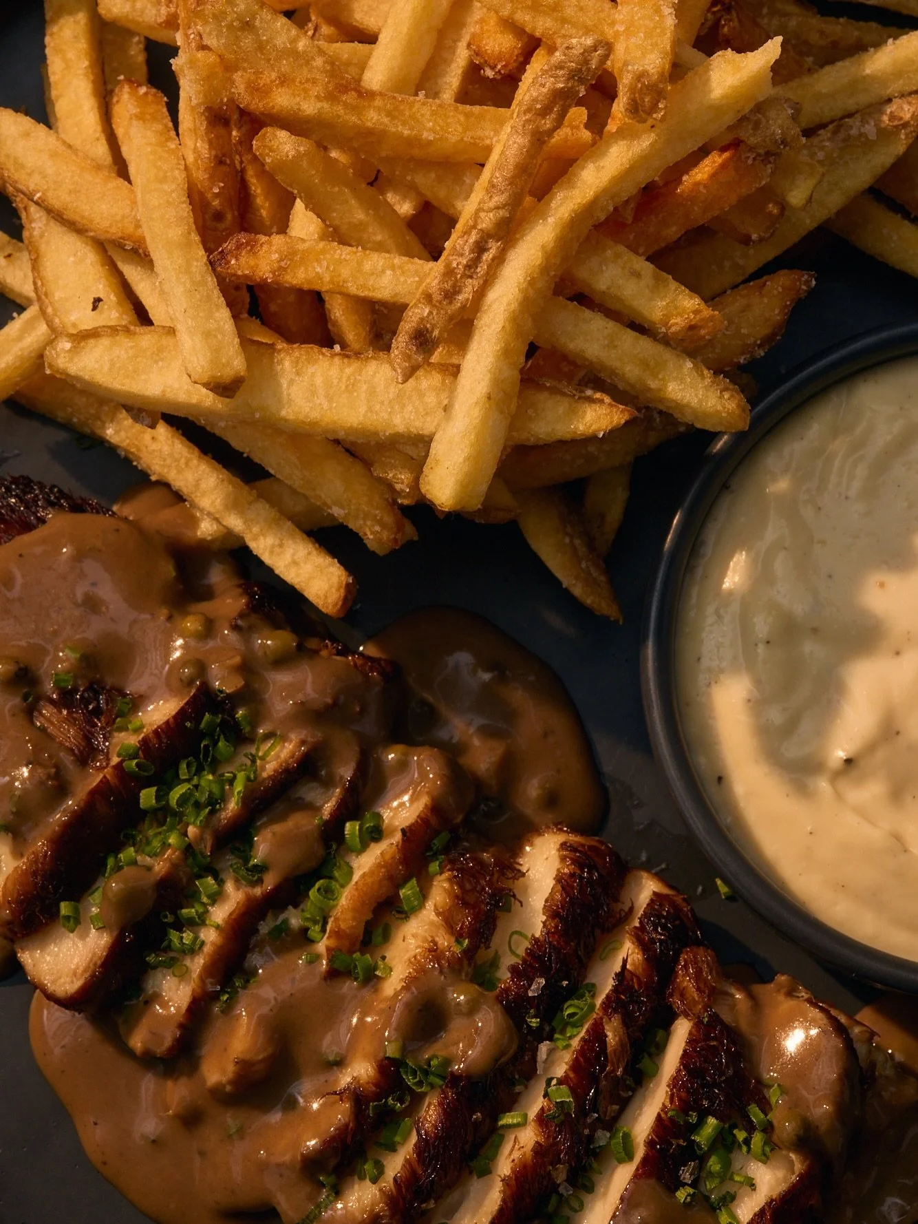 miso glazed lion&rsquo;s mane mushroom steaks, roasted and hard seared. porcini mushroom + green peppercorn sauce au poivre. perfectly salted frites + garlic aioli. you can&rsquo;t go wrong with this easy favorite. vegan + gluten free.