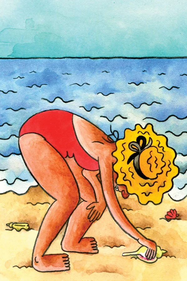 Girl bending down to pick up a shell at the beach