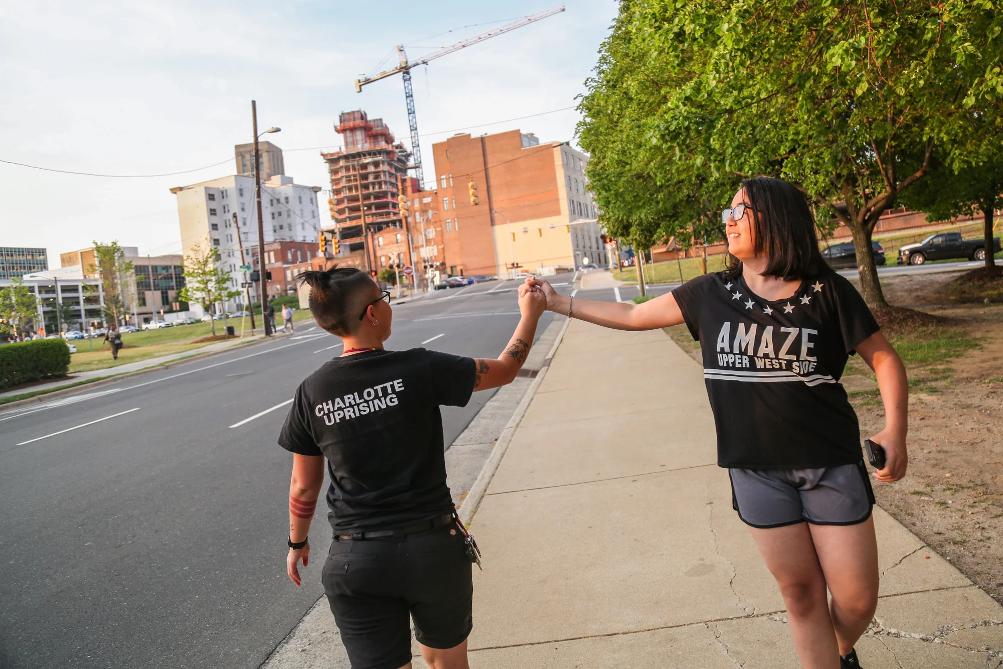 Loan and their sister Nicole Tran who has been staying with Loan during her Spring break for one week in Durham. They greet and high five for fun after the jail protest on their way to get their car.