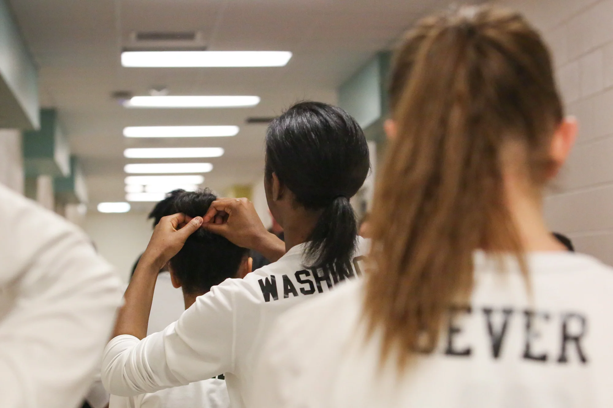 Green Hope's Nia Washington ties the hair up for another player on their way to the basketball gym on Feb.17, 2017.