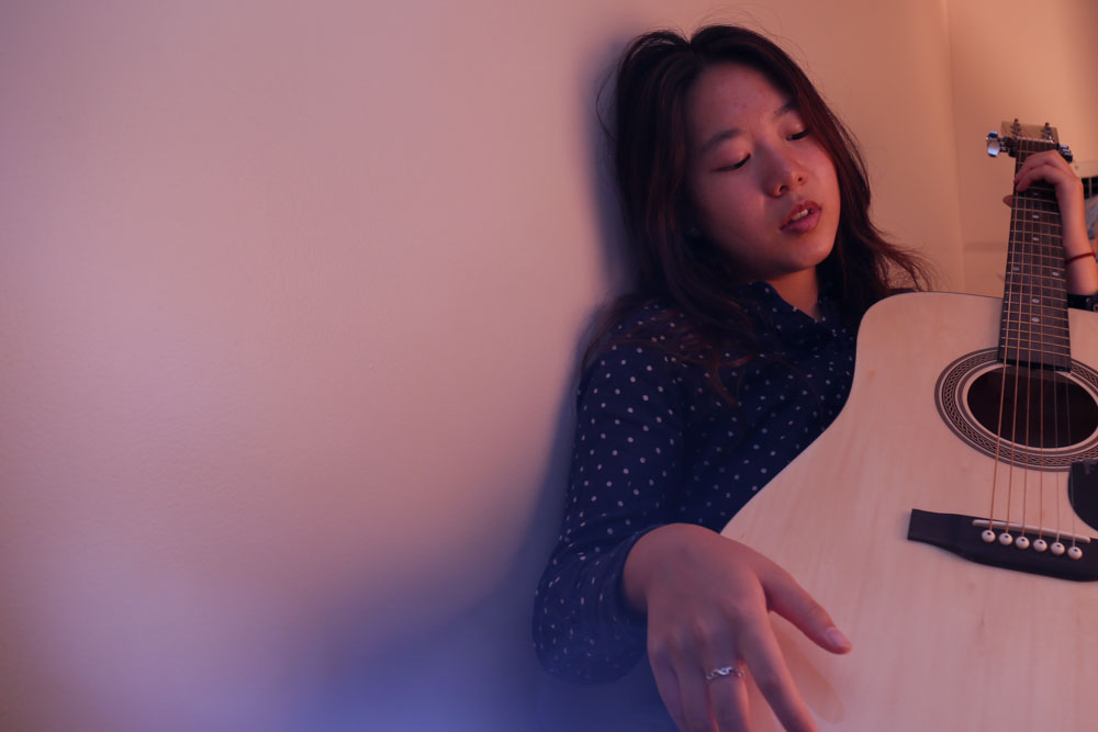 Jiayi Liu holds her guitar in her dorm bed at UNC on Sep.29, 2016.