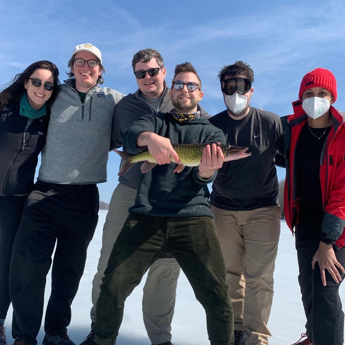  group of people with a guy standing with a fish 