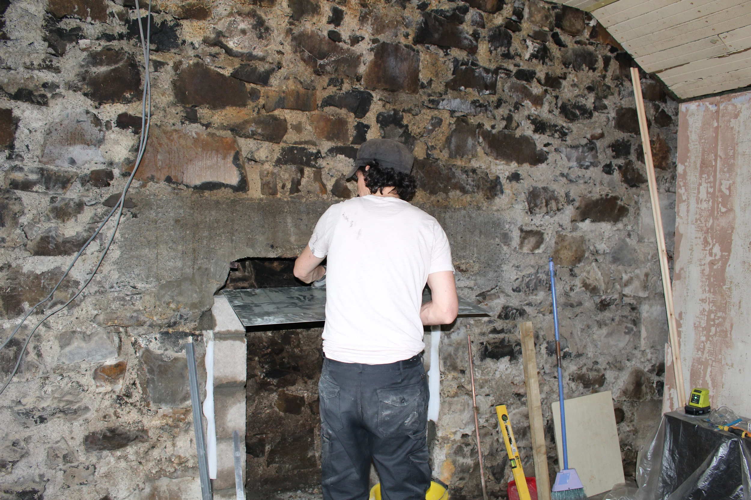 As well as closing of the chimney and providing a base for back-filling, the register plate has to allow the flue from the stove to pass through. This meant fitting the plate and marking out the centre line, then drilling a hole with a metal bit to allow a jigsaw and metal cutting blade to cut out the circle