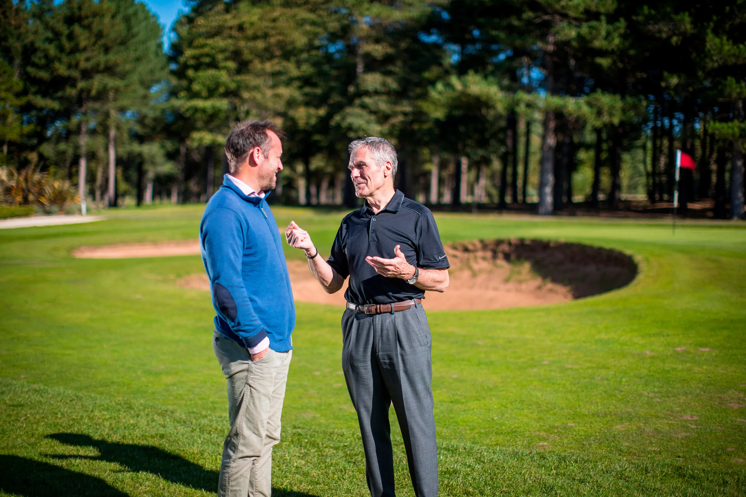 Executive coach Charlie Jackson talks with a client on a golf course