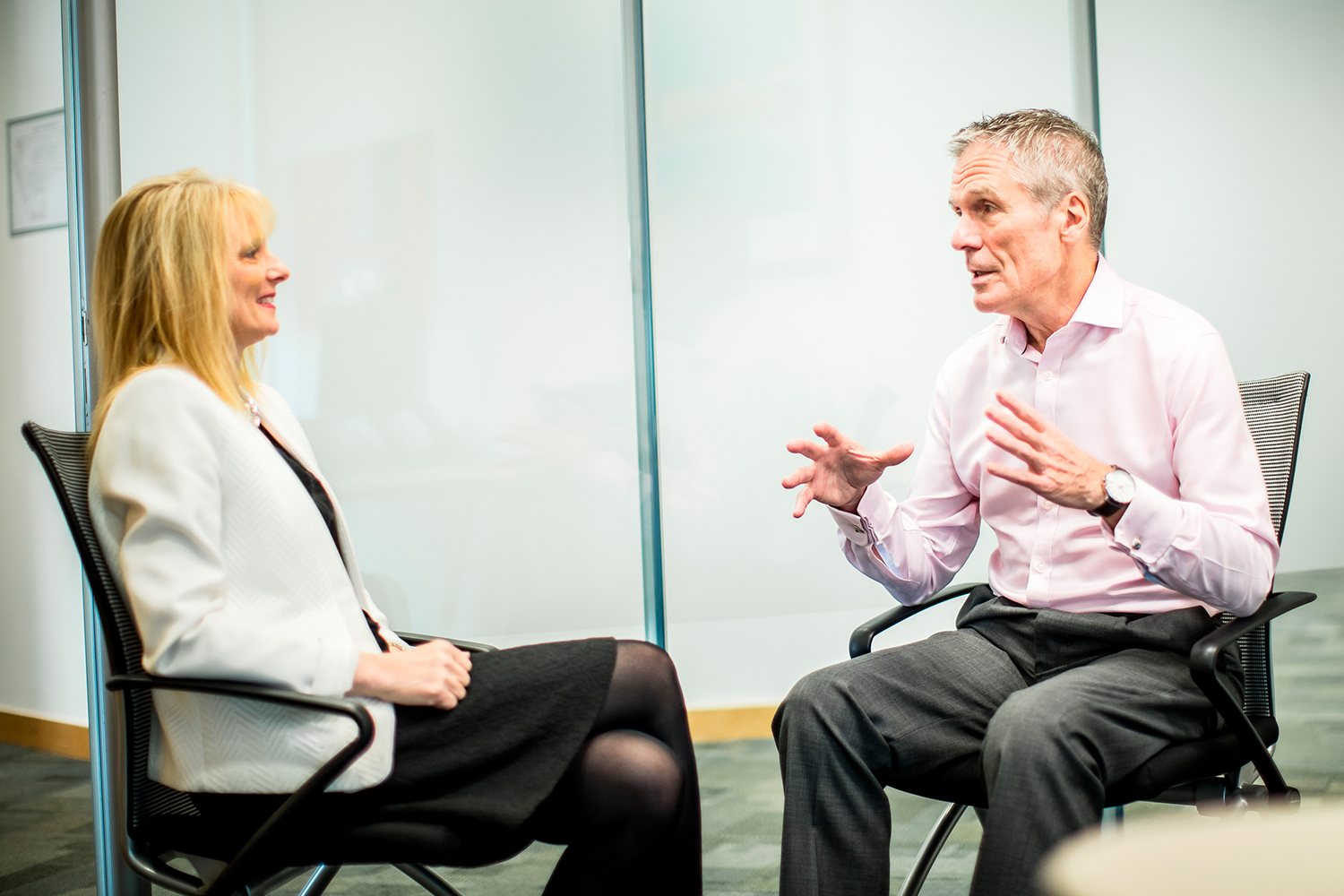 Charlie talking to a woman client in a smart office setting