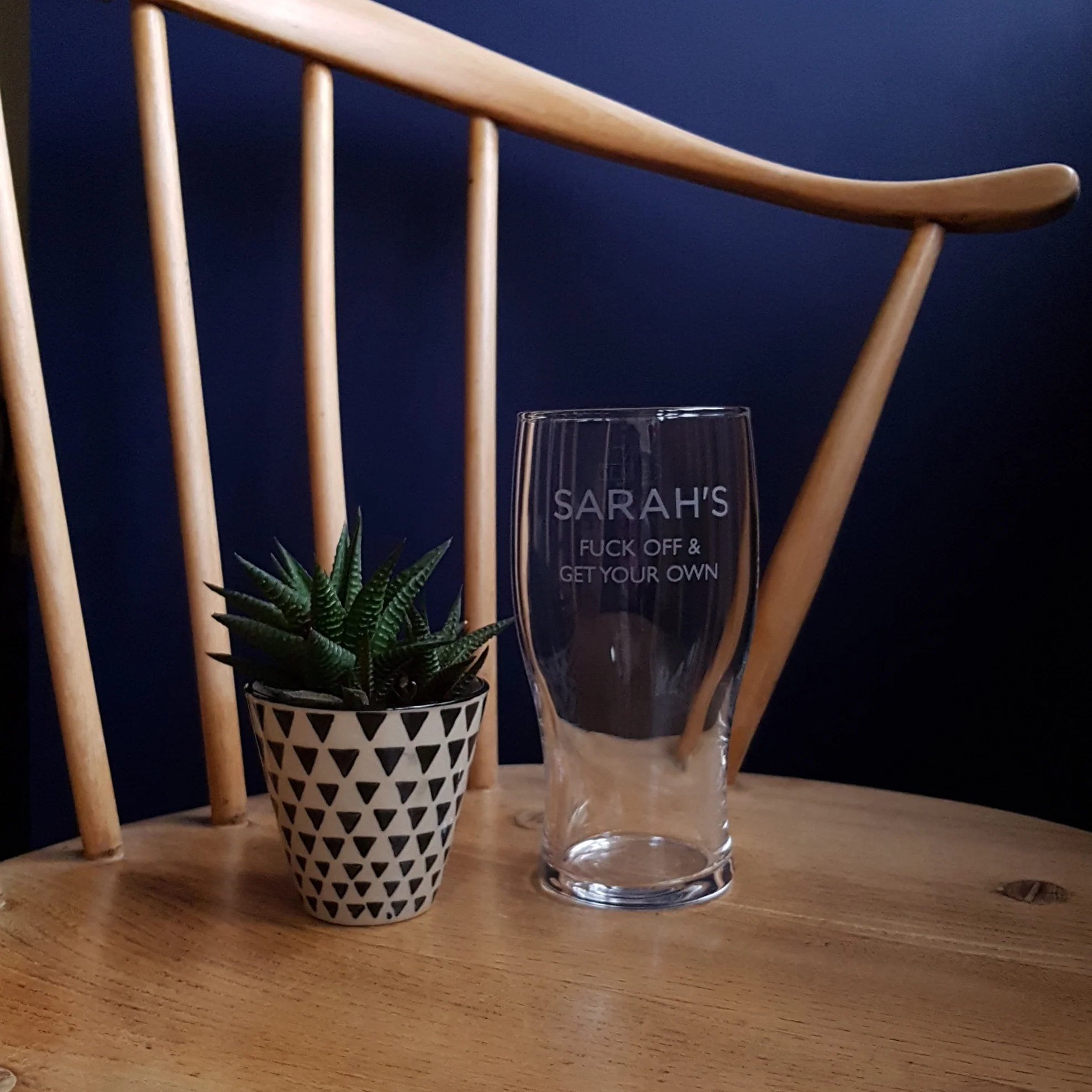 Sweary Get Your Own Pint Glass on chair.jpg