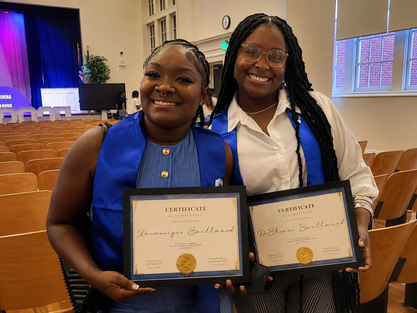 Two educators receiving certificates during a recognition ceremony.