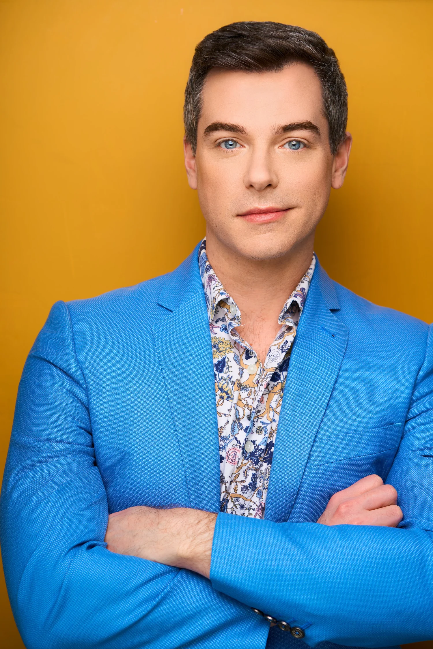 Trey Gerrald in a blue suit against a warm amber background