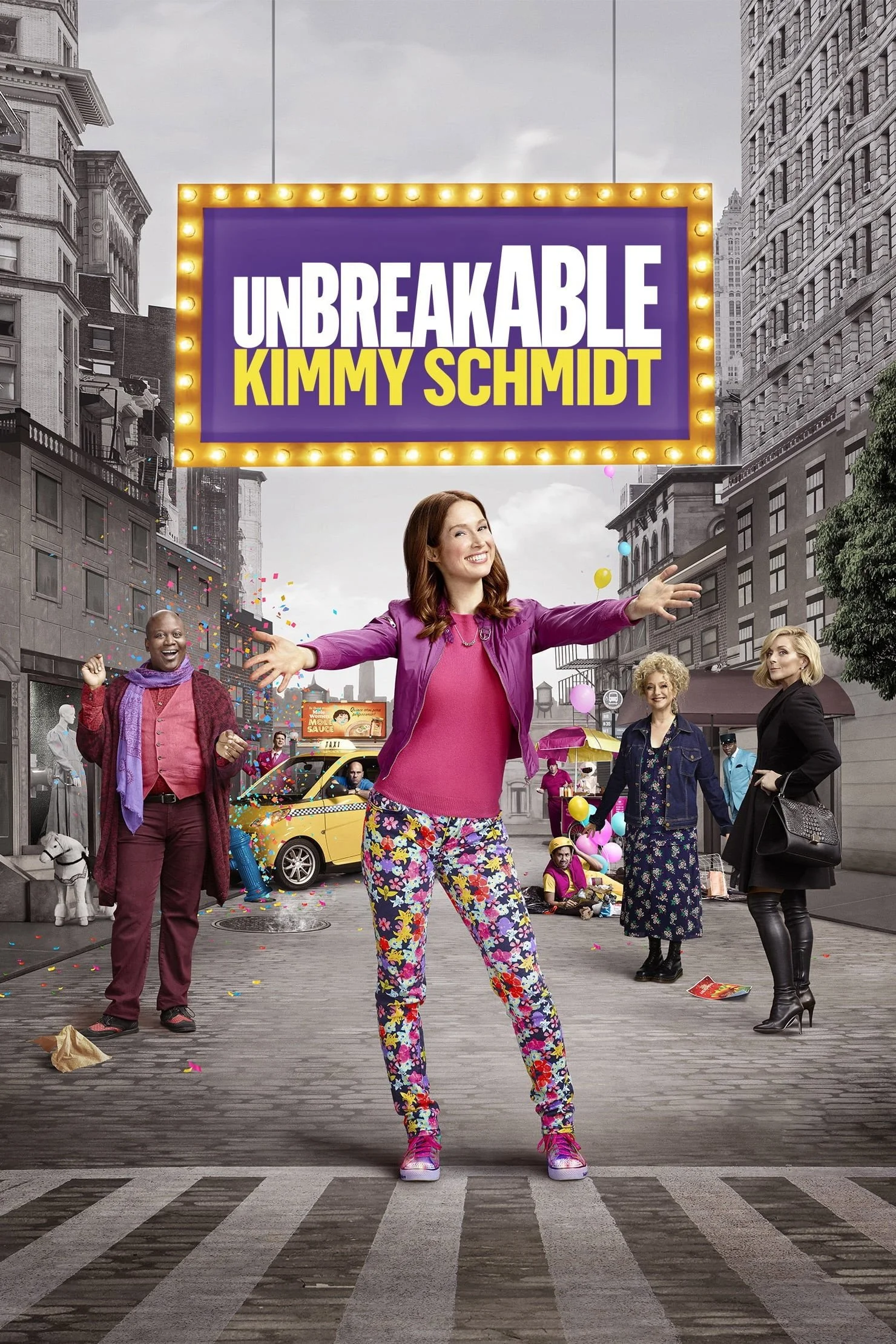 A street scene with diverse people celebrating, with a large illuminated sign that reads "Unbreakable Kimmy Schmidt", as colorful confetti falls. The central figure is a woman in bright floral pants and a pink top, smiling and extending her arms. Oth