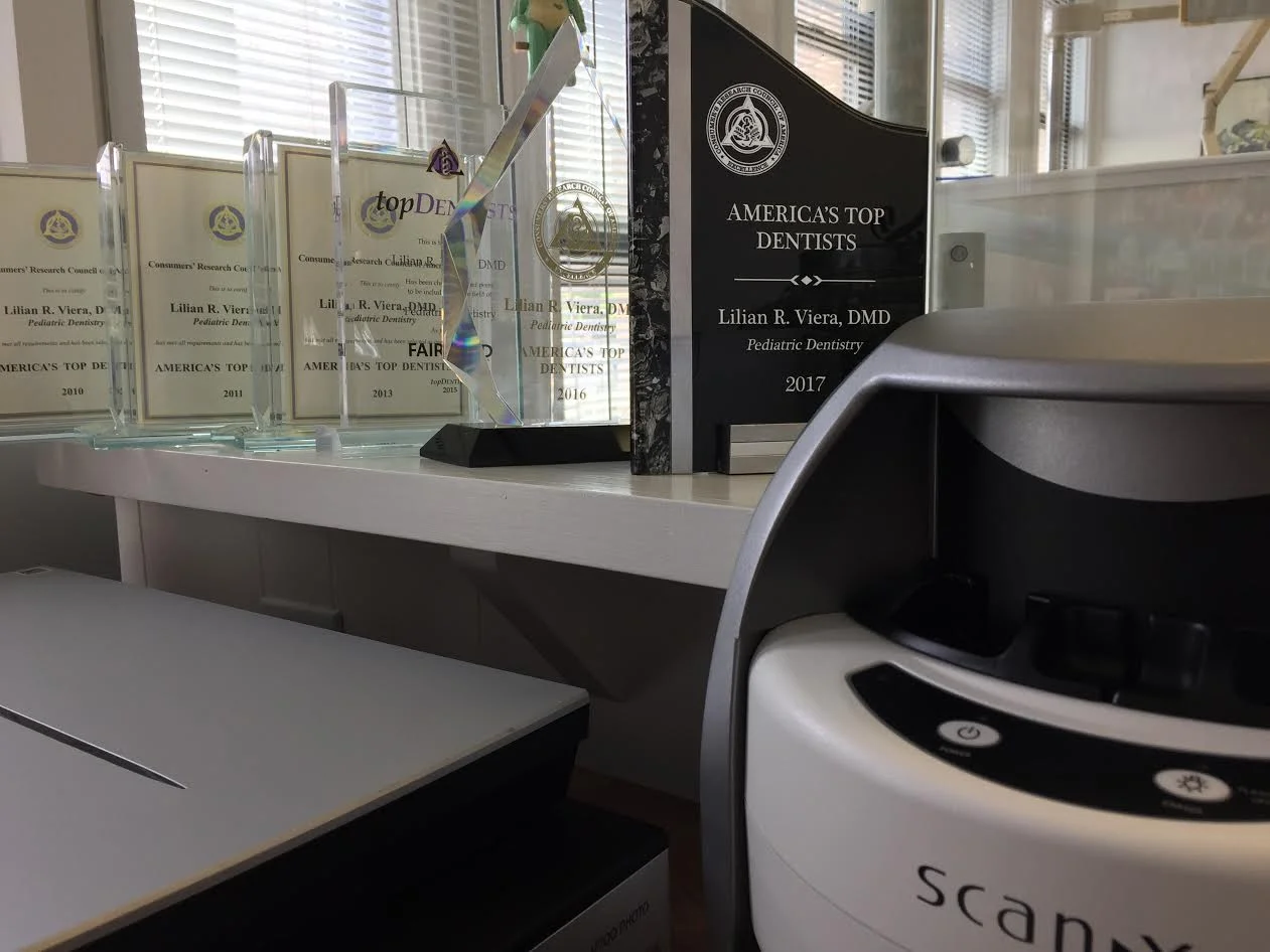 Dr. Viera's "America's Top Dentists" Awards from 2010, 2011, 2013, 2015, 2016, and 2017. X-ray developer and scanner on bottom. This is the meeting room where Dr. Viera goes over treatment plans with patients and parents.