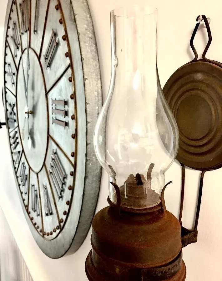 Galvanized giant clock and hanging oil lamp.