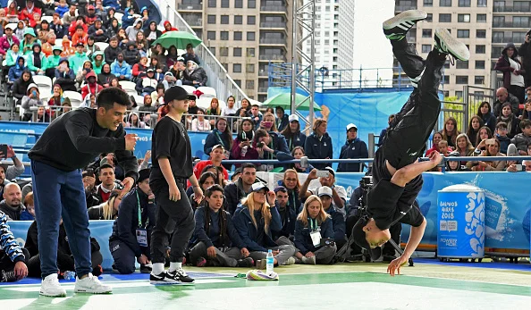 "Broly," left, from Argentina and "Lexy," center, from Italy watching "B4," right, from Vietnam at the final of the 2018 Youth Games breaking competition // Getty Images