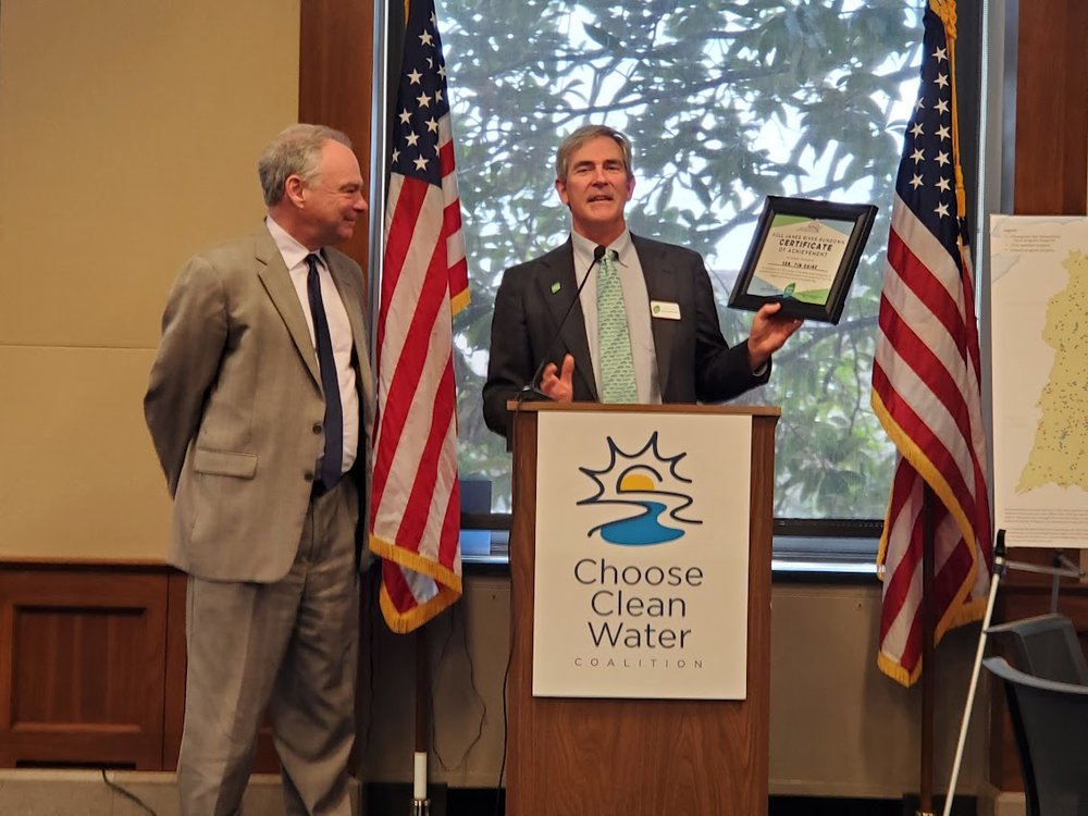  James River Association President and CEO Bill Street awarding Sen. Tim Kaine (D-VA) with the “Full James River Rundown,” for paddling the full mainstem of the James River 