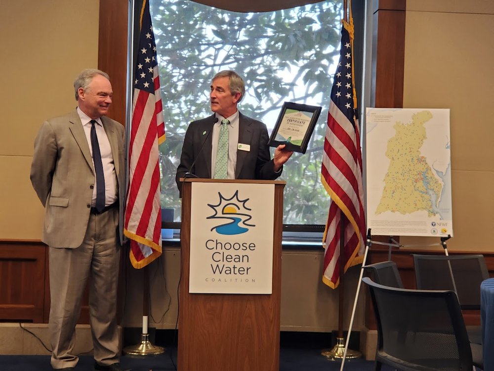  James River Association President and CEO Bill Street awarding Sen. Tim Kaine (D-VA) with the “Full James River Rundown,” for paddling the full mainstem of the James River 