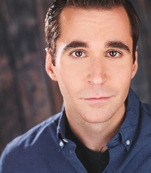 A white man with brown hair wearing a blue shirt