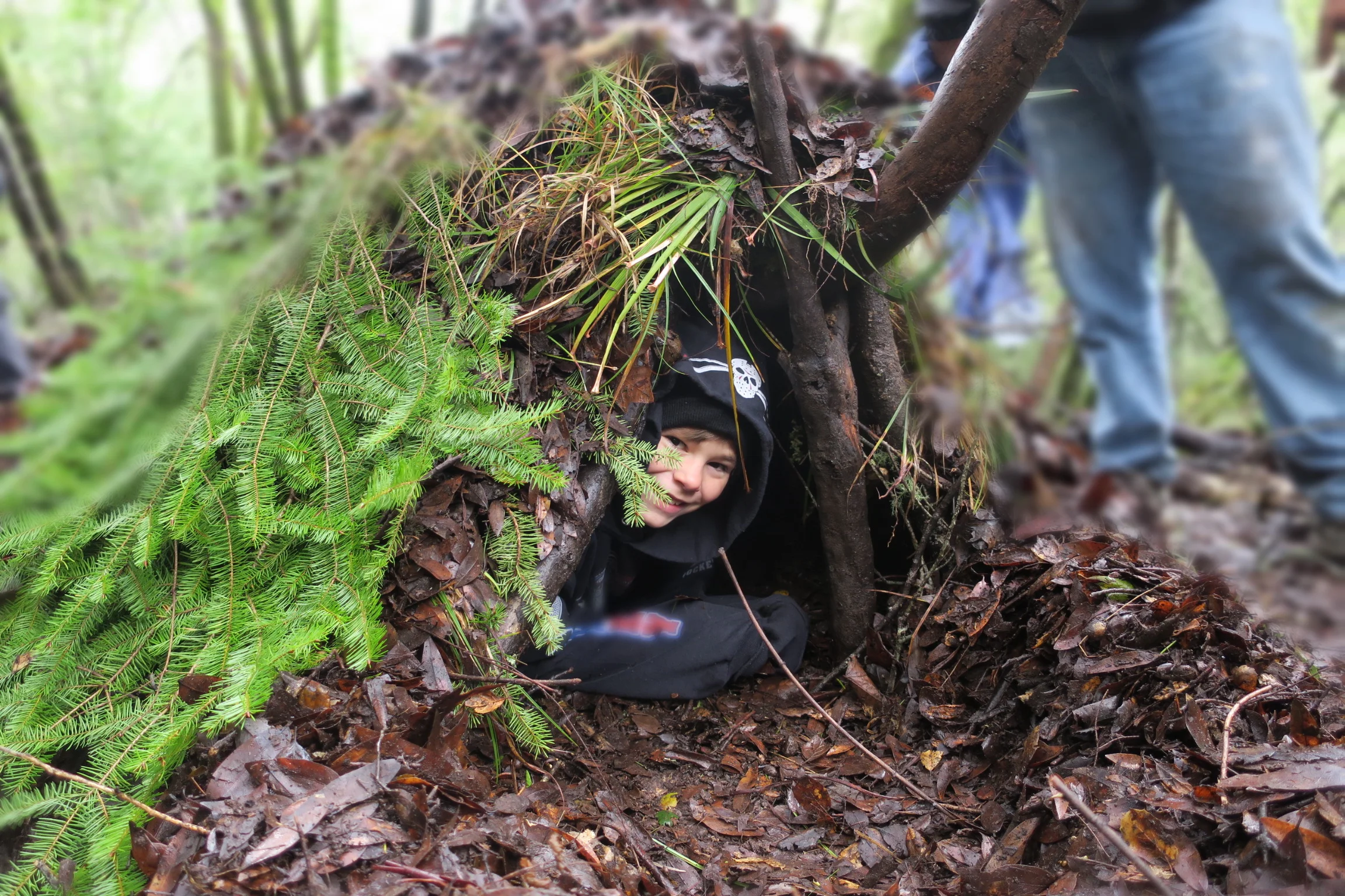 Kid in debris hut.JPG