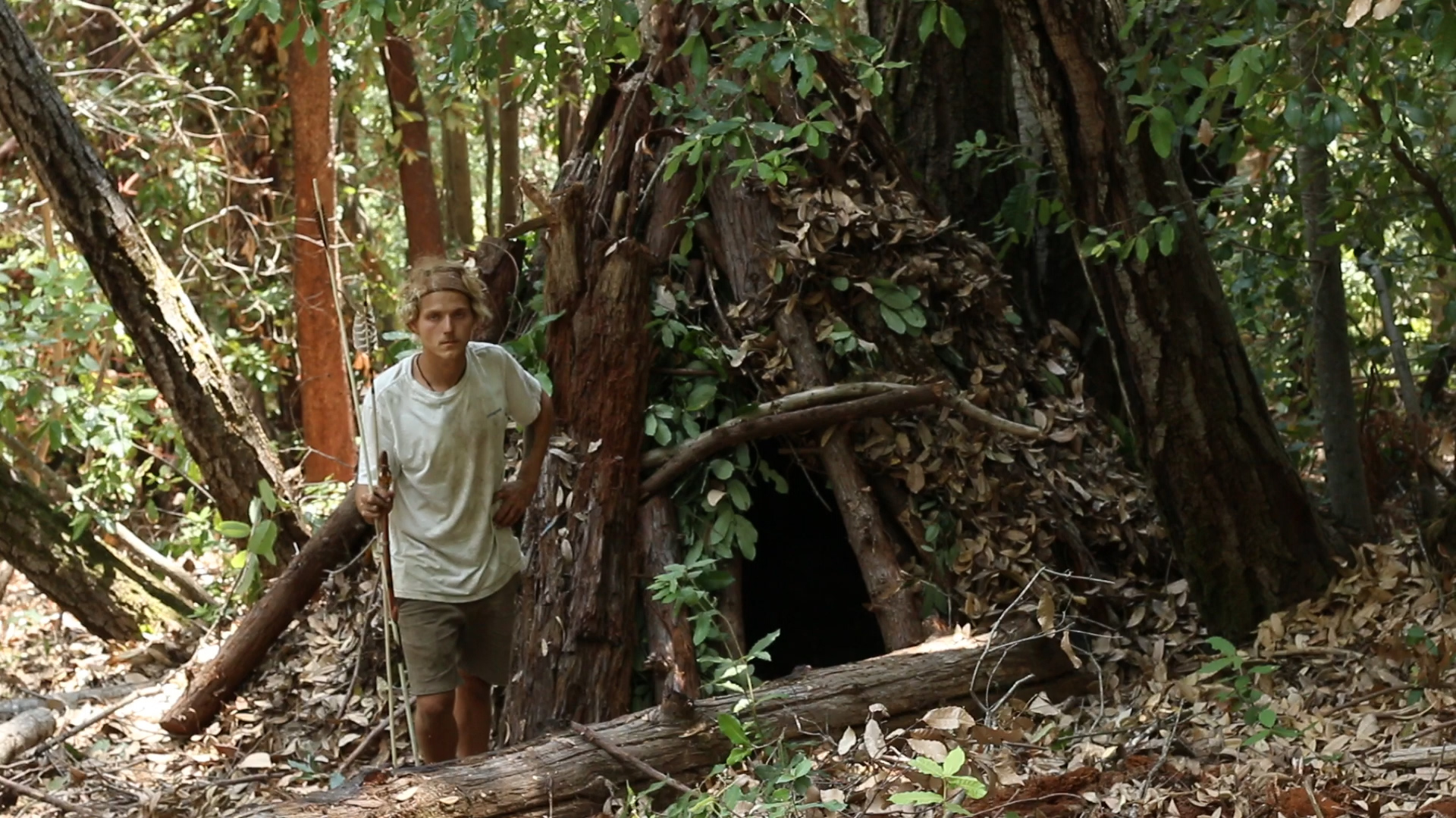My Wikiup home, located deep in the santa cruz mountains. Without camo it would have likely been vandalized as many of my primitive homes have. Under the camo is a spiraling pattern of large logs covered in bark, build over a 3 foot deep pit dug into the ground lined with sand and floor was eventually covered in large flat rocks (tile). Live Tan oak trees were woven in to further blend it in throughout the seasons. 
