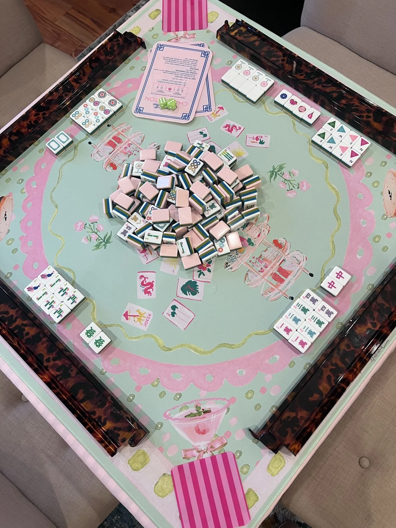 Overhead view of an American mahjong table with tiles, racks, and a player card.