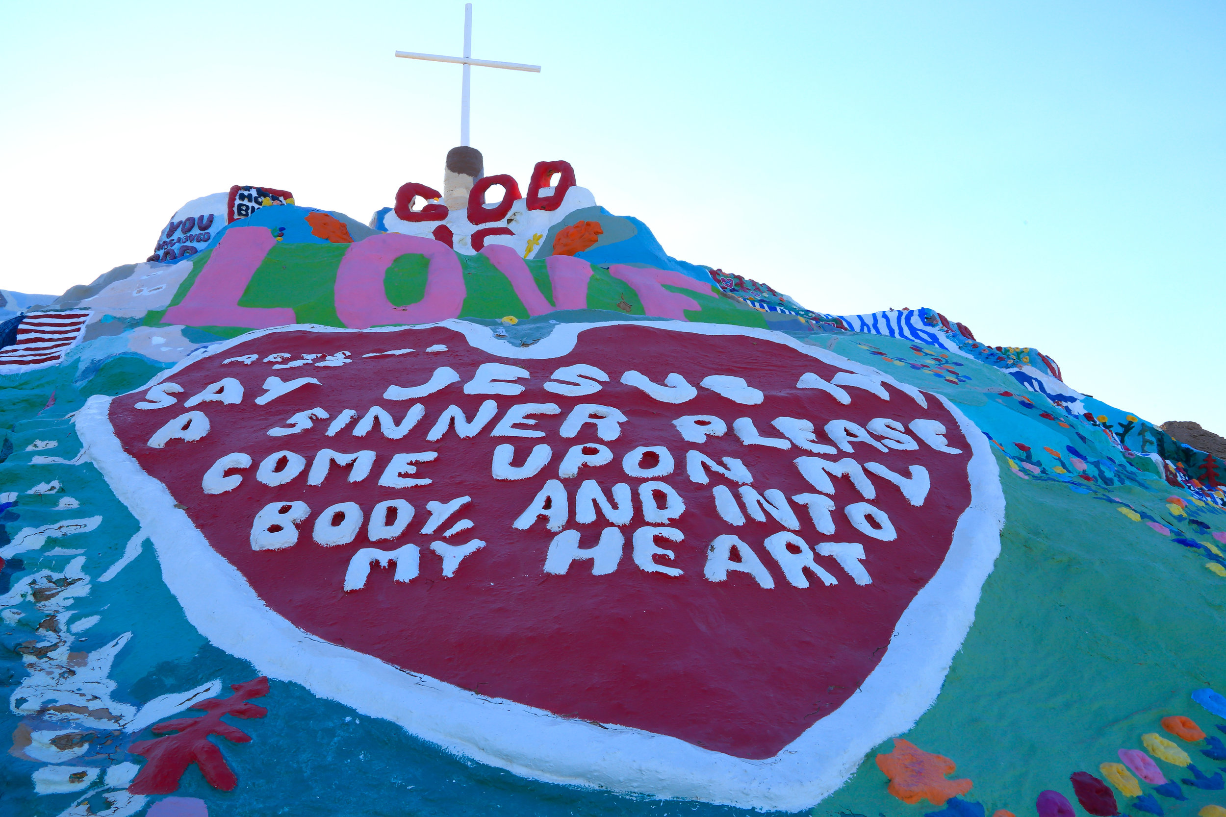 The sun about to rise above the pinnacle of Salvation Mountain.