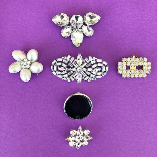 Pearl earring, diamante broaches, black button and a gold shoe clip