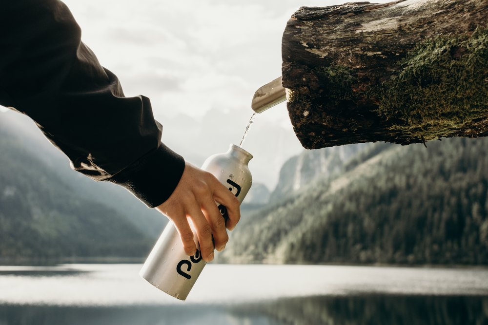 reusable+water+bottle+being+refilled+outside.jpeg