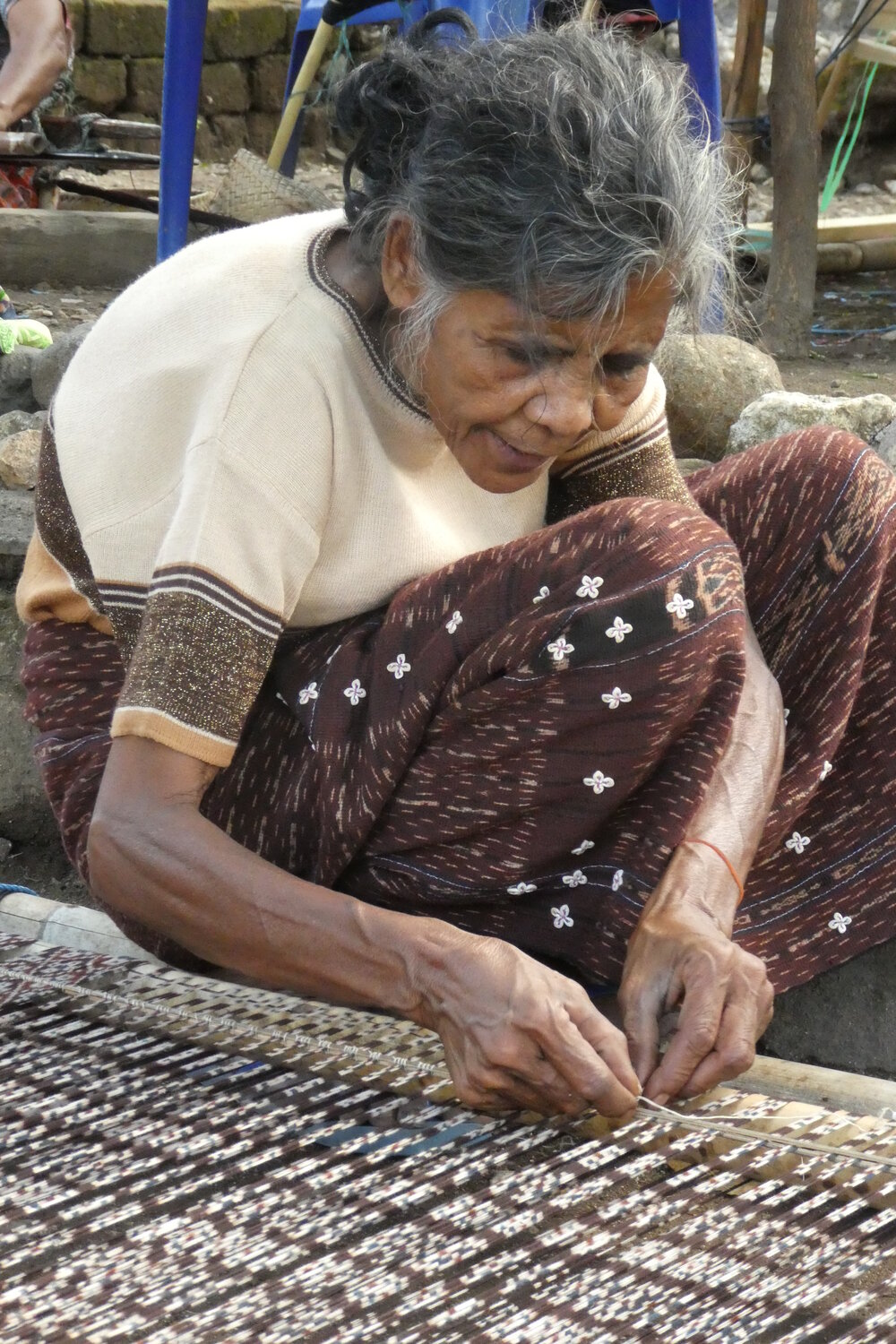 Alighning a loom with warp tied and dyed threads before weaving.JPG