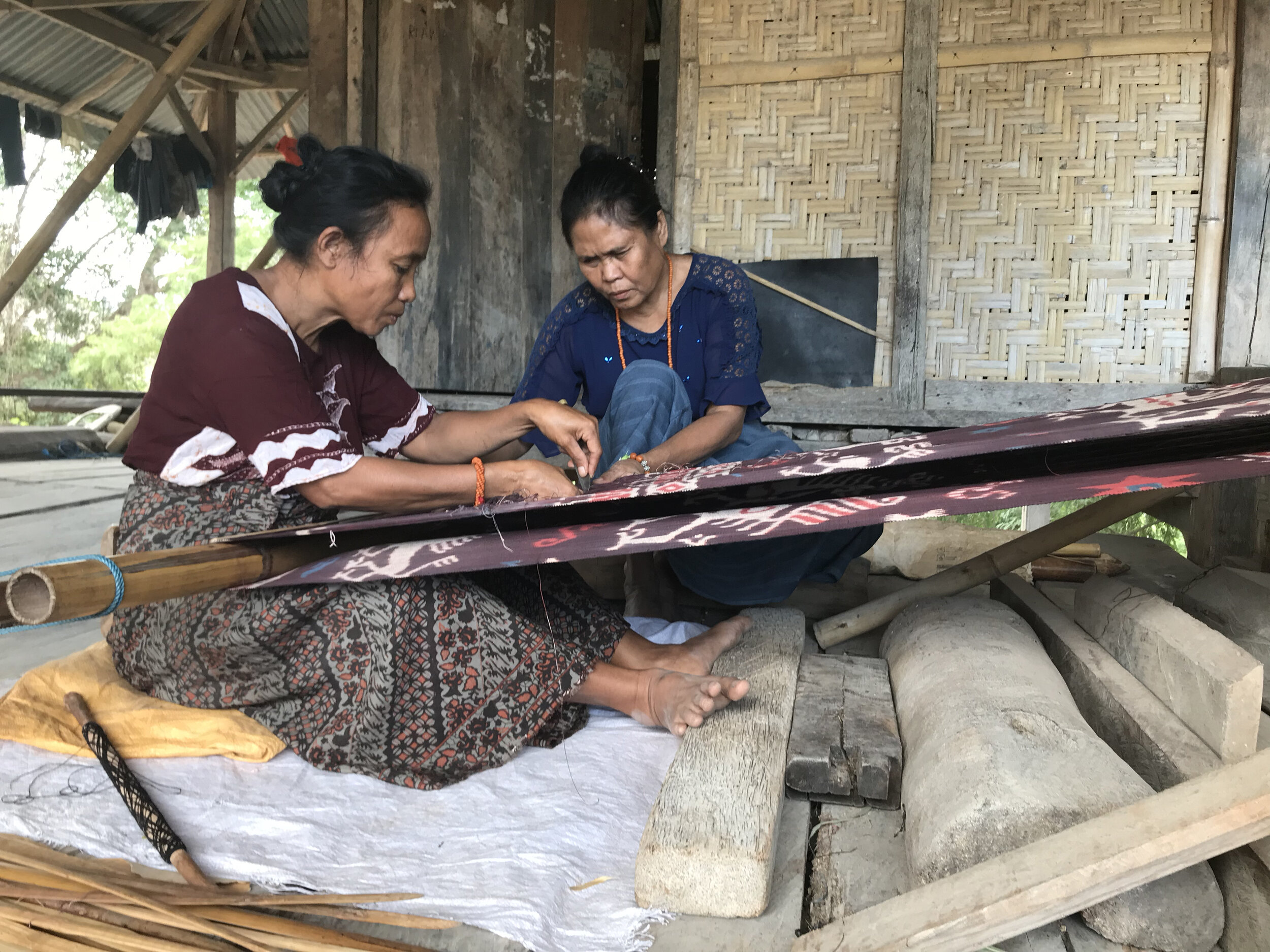 Working together to repair broken threads during the weaving process.jpg