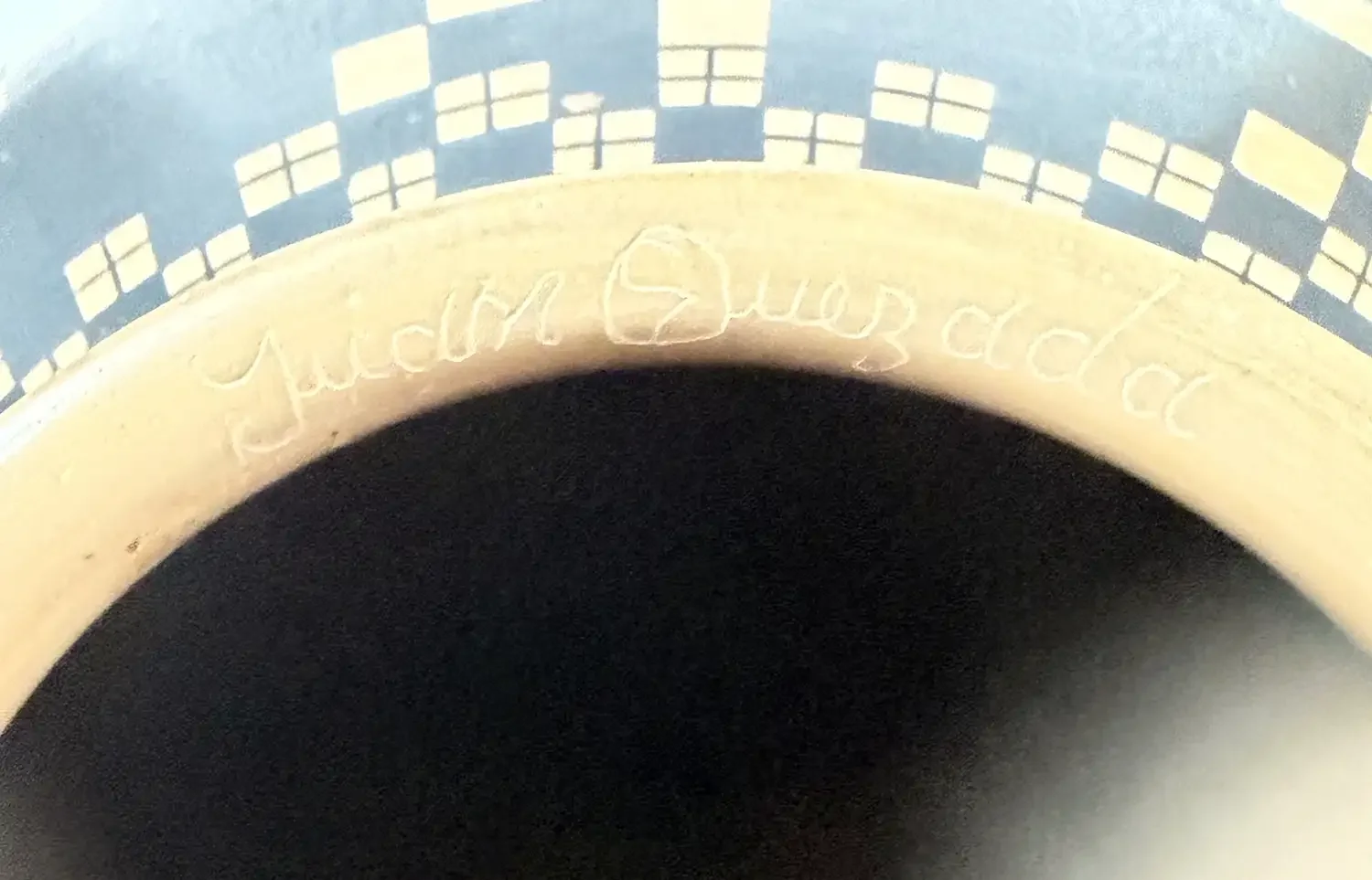 Close-up of Juan Quezada signature incised inside the neck ring of a black-on-white Mata Ortiz olla.