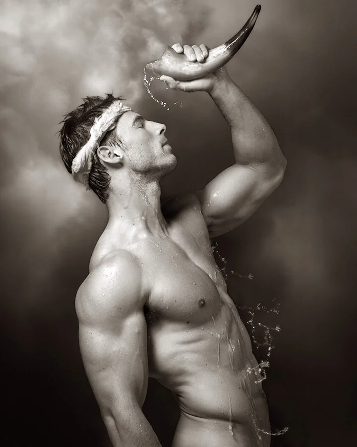 Digital print Water Horn by Mark Jenkins with Male nude of figure holding water horn above his head against a tranquil background of cloud forms.