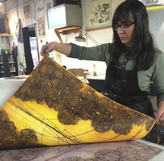 Elise Wagner in her studio lifting an encaustic collagraph wax plate