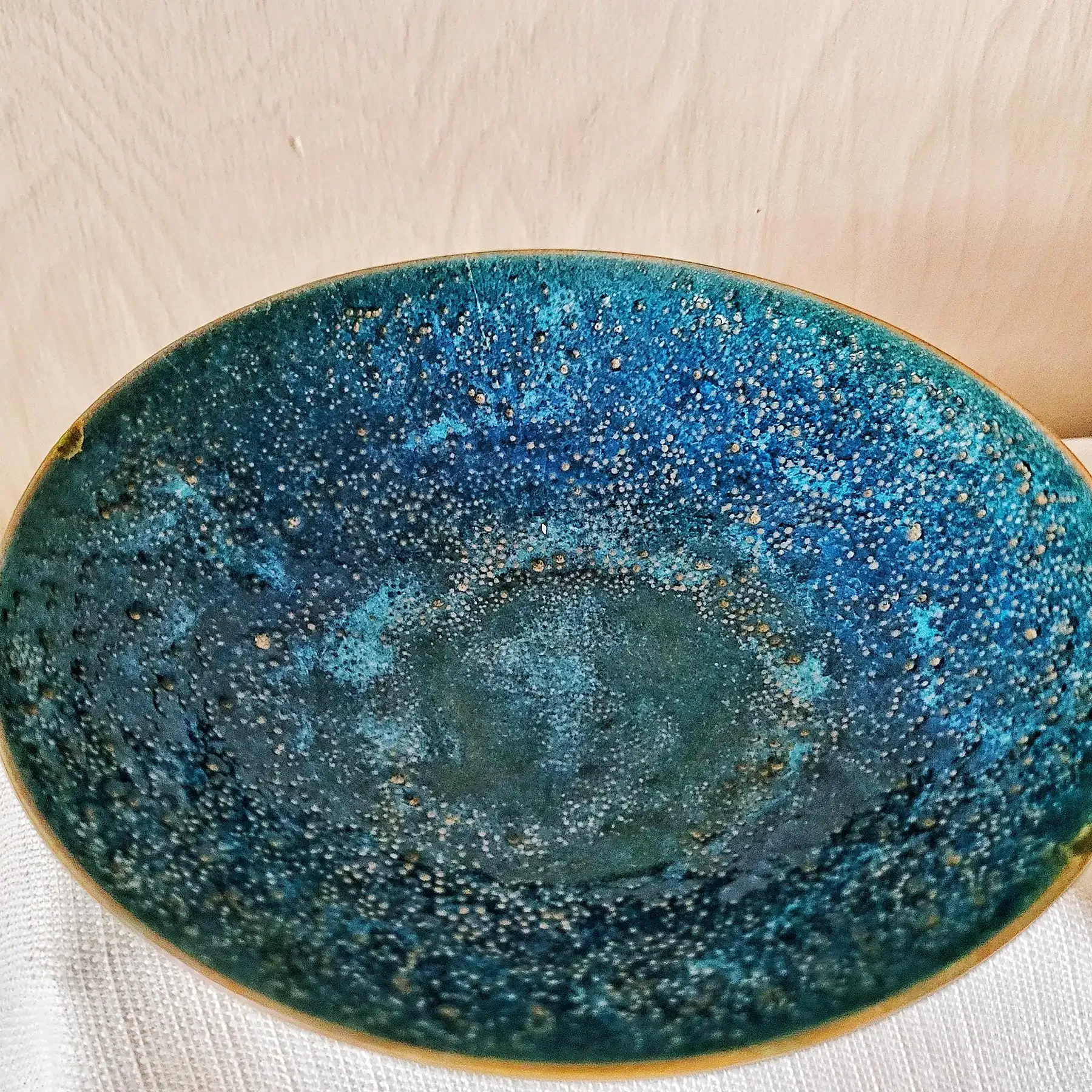 Top view of Natzler Prussian green–blue bowl showing cratered glaze surface and rich blue-green tonal variations.