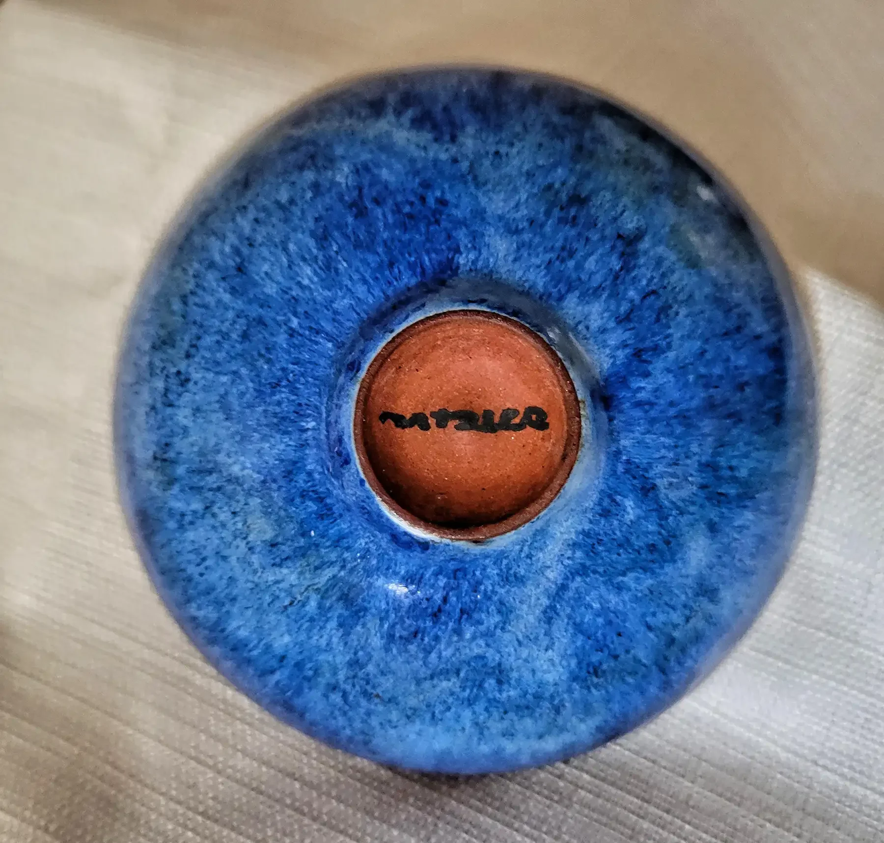 Bottom view of a Gertrud and Otto Natzler earthenware bowl with Blue Hare’s Fur glaze, showing Natzler signature