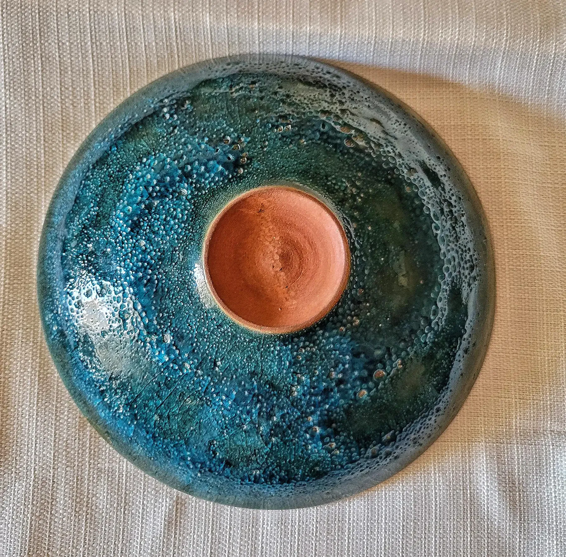 Underside of Otto and Gertrud Natzler bowl showing Prussian green–blue crater glaze and Natzler signature.